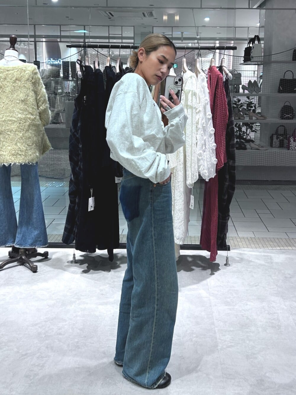 ブルー系のデニムパンツ、グレー系のTシャツ/カットソーを着用したレディースの秋コーディネートの2枚目の写真