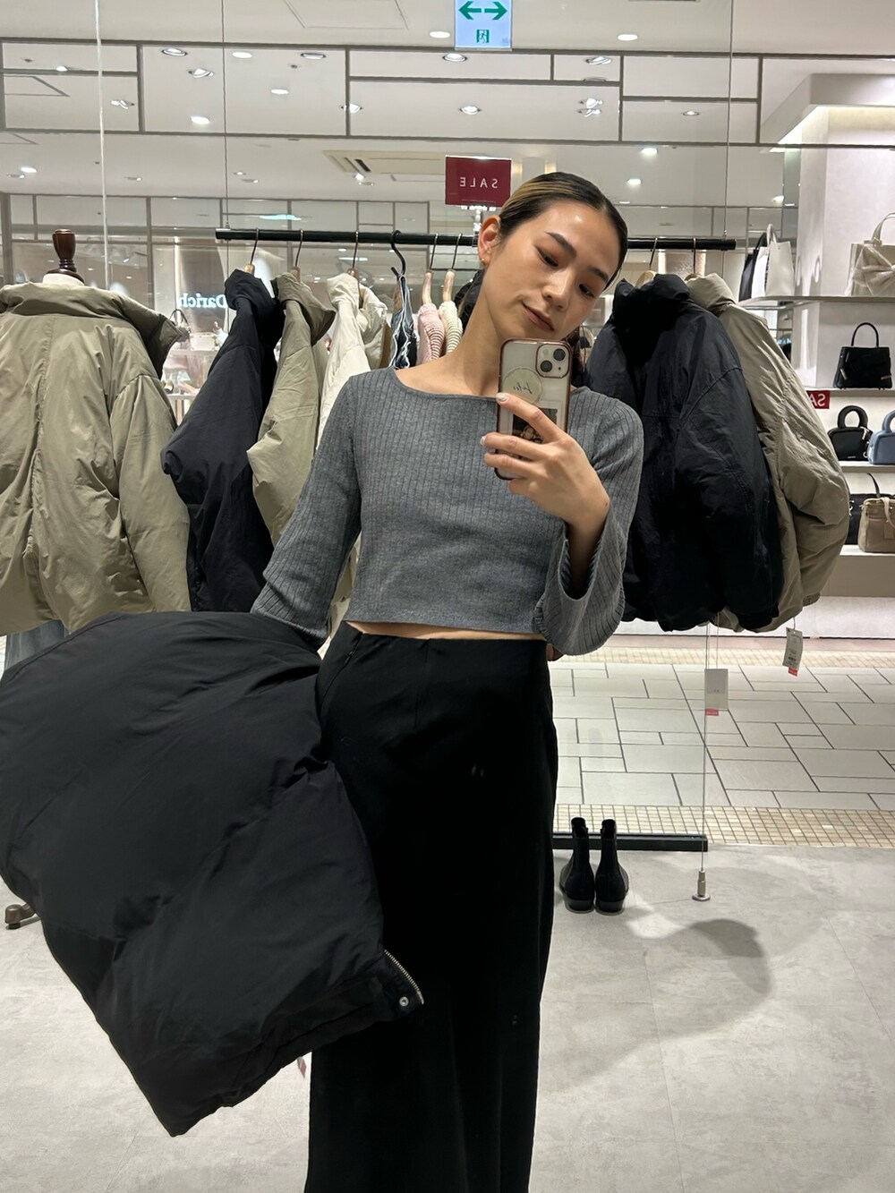 ブラック系のスカート、ブラック系のダウンジャケット/コート、グレー系のニット/セーターを着用したレディースの冬コーディネートの5枚目の写真