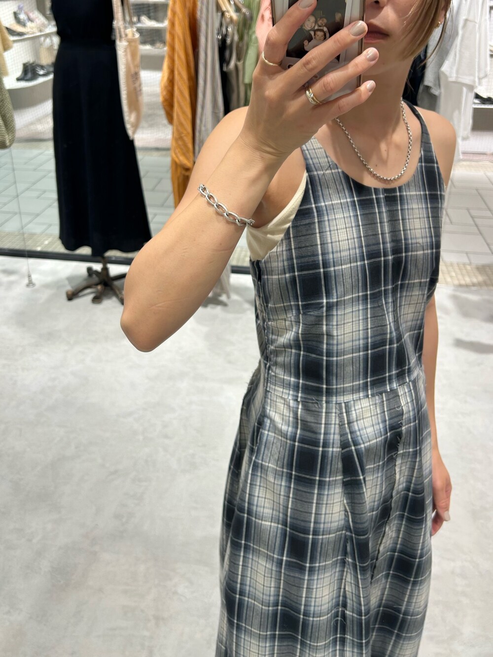 ブルー系のワンピース、ホワイト系のキャミソール、ブルー系のデニムパンツを着用したレディースの夏コーディネートの5枚目の写真