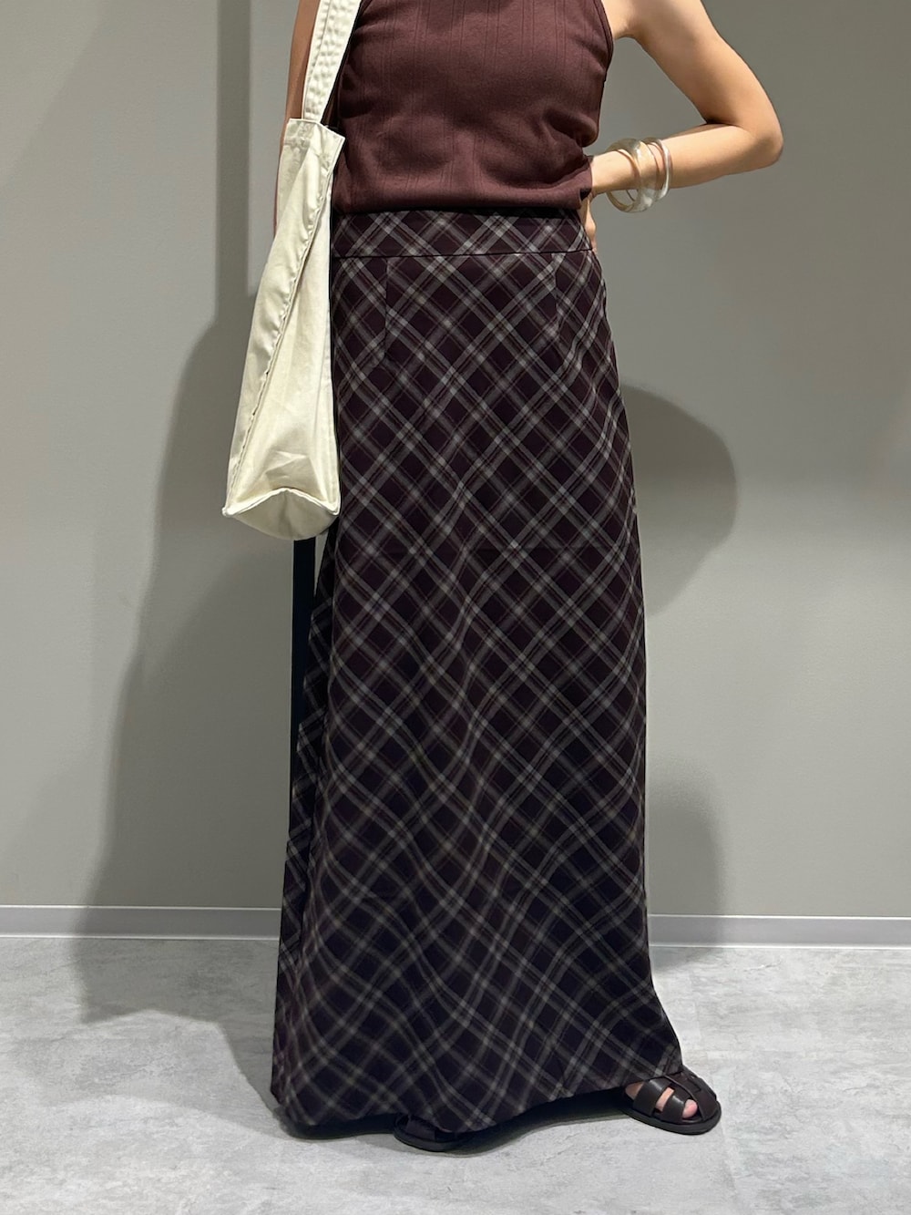 ブラウン系のスカート、ブラウン系のタンクトップ、ホワイト系のトートバッグを着用したレディースの夏コーディネートの4枚目の写真