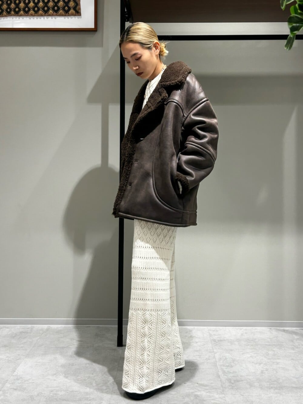 ブラウン系のブルゾン、ホワイト系のニット/セーター、グレー系のその他パンツを着用したレディースの秋コーディネートの2枚目の写真