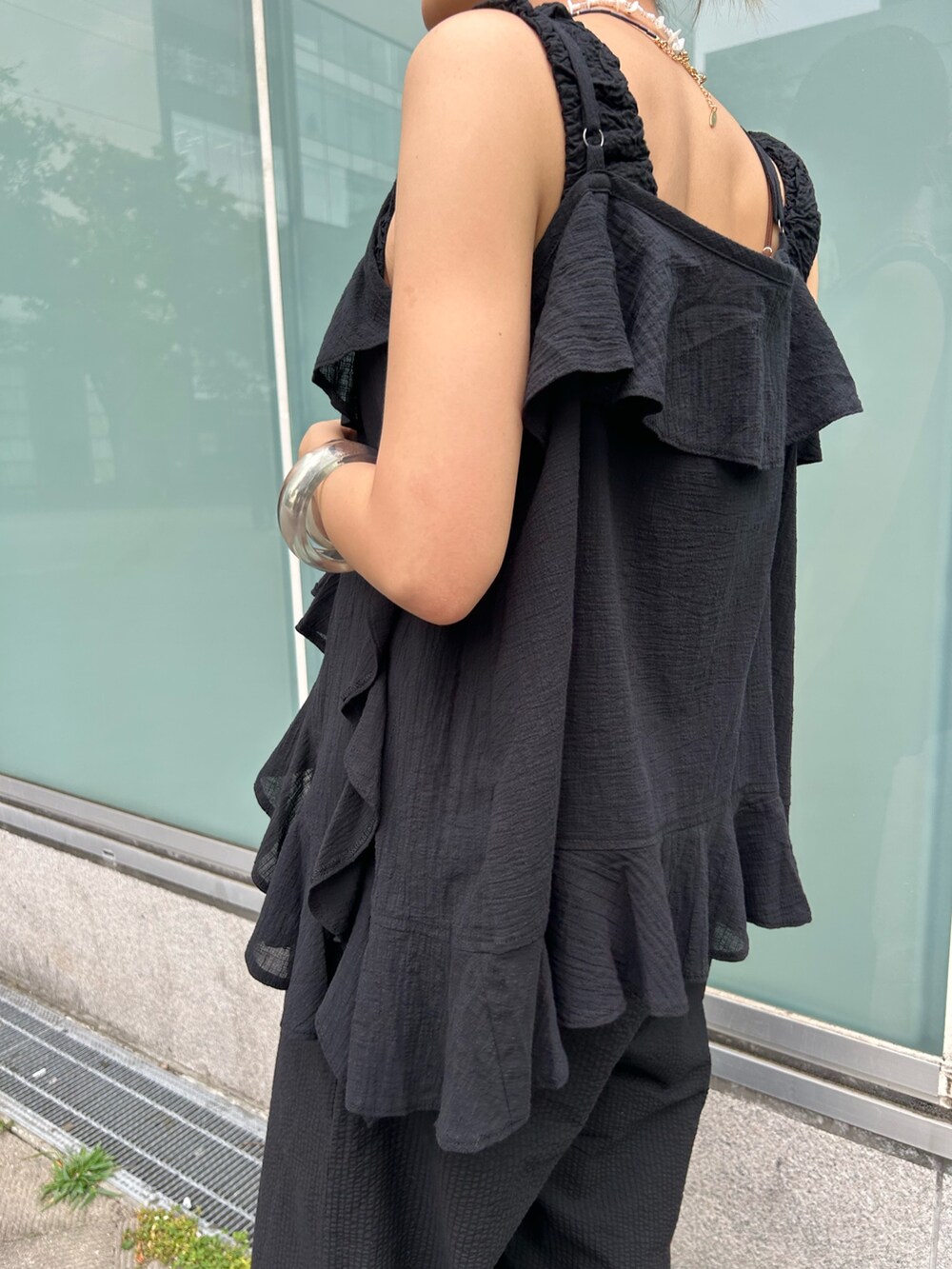 ブラック系のつなぎ/オールインワン、ブラック系のキャミソール、シルバー系のサンダルを着用したレディースの夏コーディネートの6枚目の写真