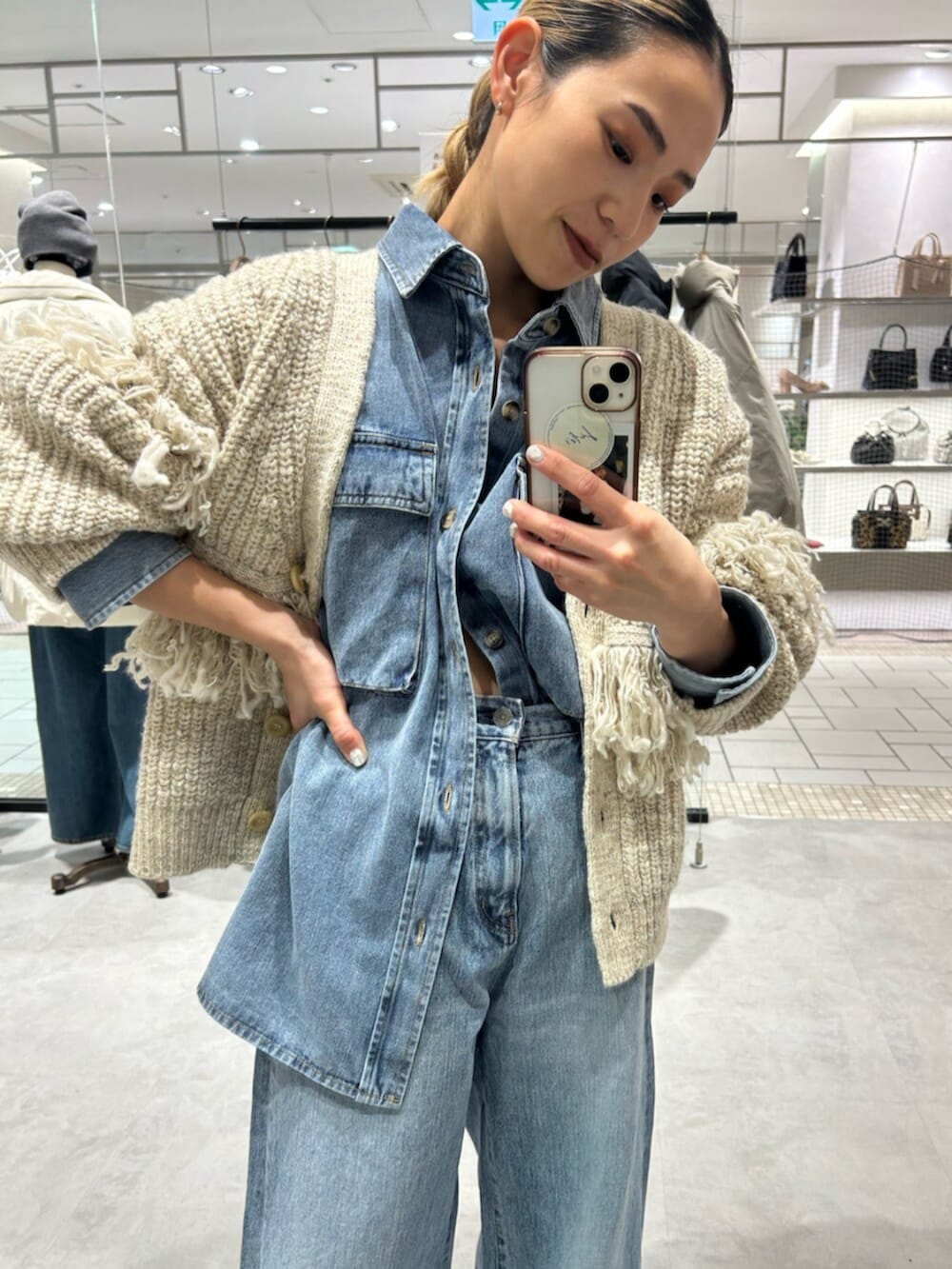 ブルー系のデニムパンツ、ホワイト系のカーディガン/ボレロ、ブルー系のシャツ/ブラウスを着用したレディースの冬コーディネートの4枚目の写真