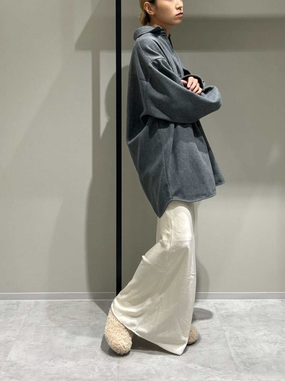 ブラック系のブルゾン、ホワイト系のスリッポン、グレー系のシャツ/ブラウスを着用したレディースの秋コーディネートの2枚目の写真