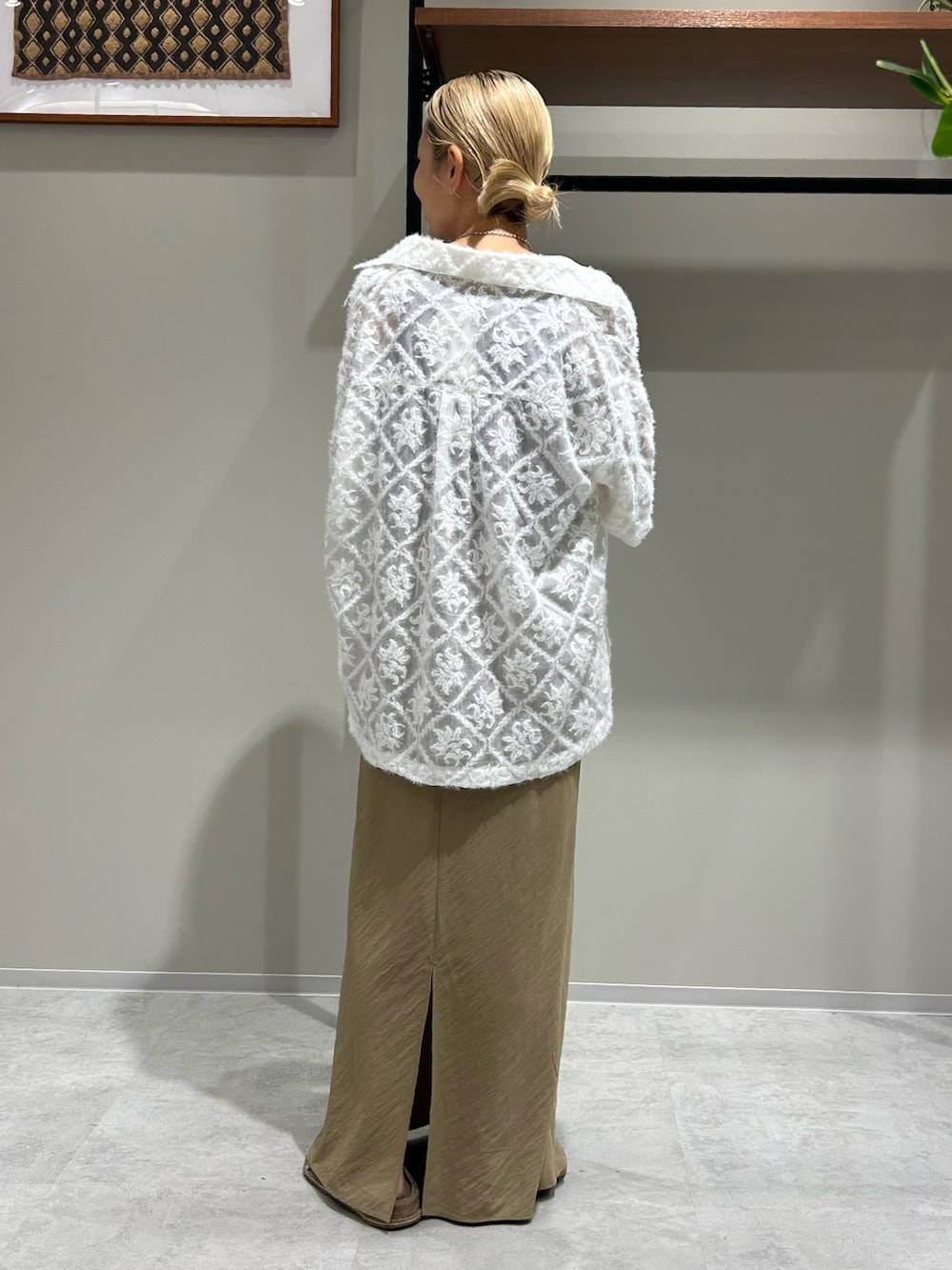 ベージュ系のスカート、ブラウン系のタンクトップ、ホワイト系のシャツ/ブラウスを着用したレディースの夏コーディネートの3枚目の写真