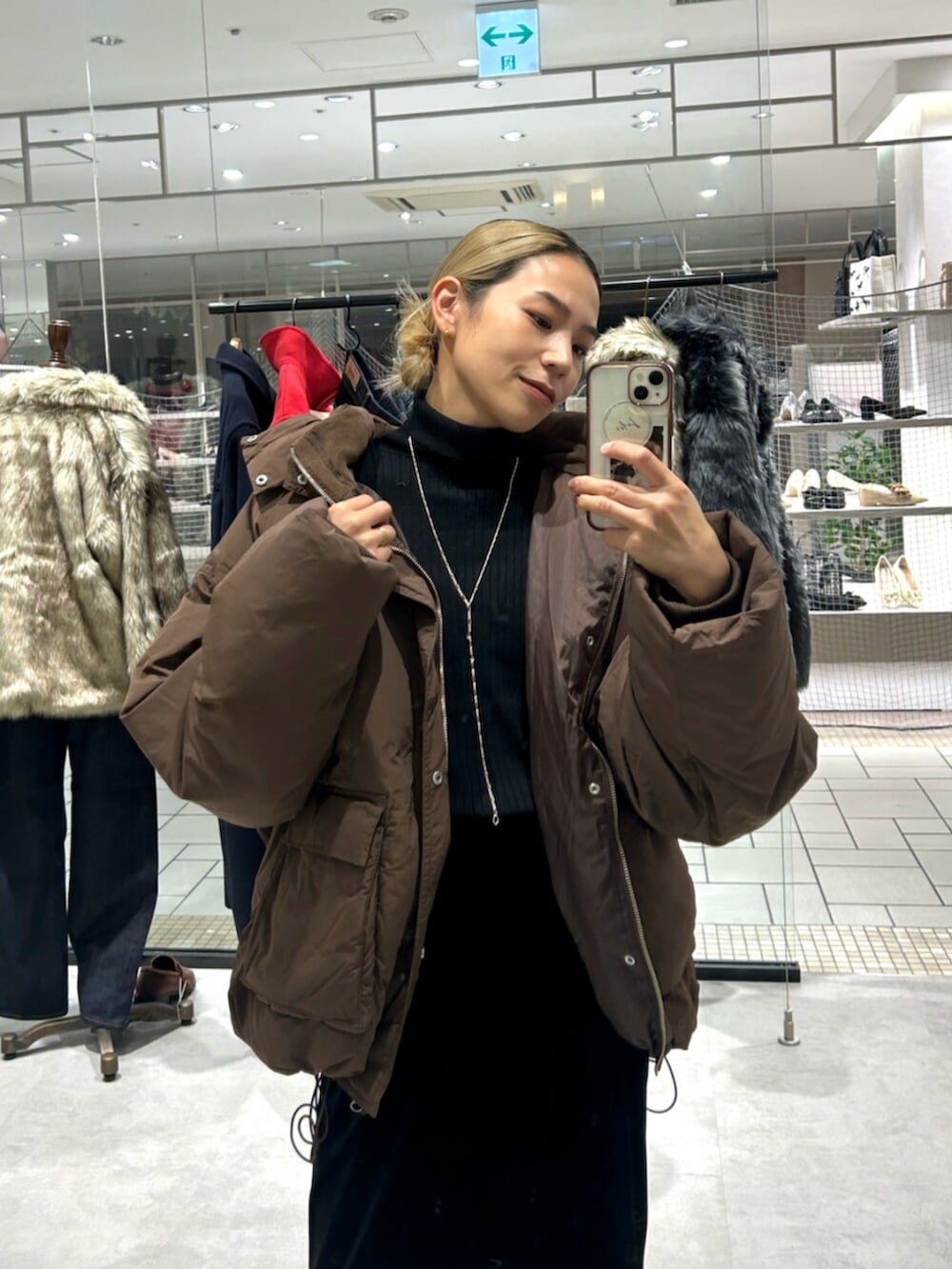 ブラック系のスカート、ベージュ系のローファー、ブラウン系のダウンジャケット/コートを着用したレディースの秋コーディネートの4枚目の写真