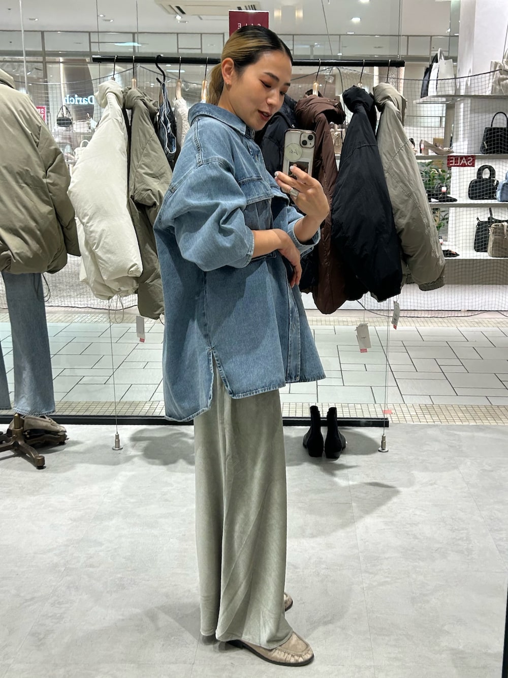 ブルー系のシャツ/ブラウス、グレー系のスカート、ベージュ系のローファーを着用したレディースの冬コーディネートの2枚目の写真