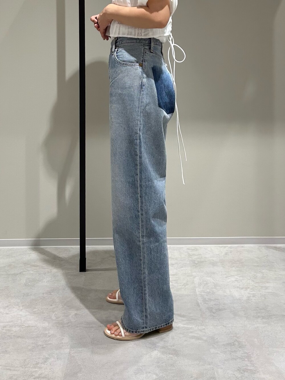 ブルー系のデニムパンツ、ホワイト系のキャミソール、ホワイト系のTシャツ/カットソーを着用したレディースの春コーディネートの5枚目の写真