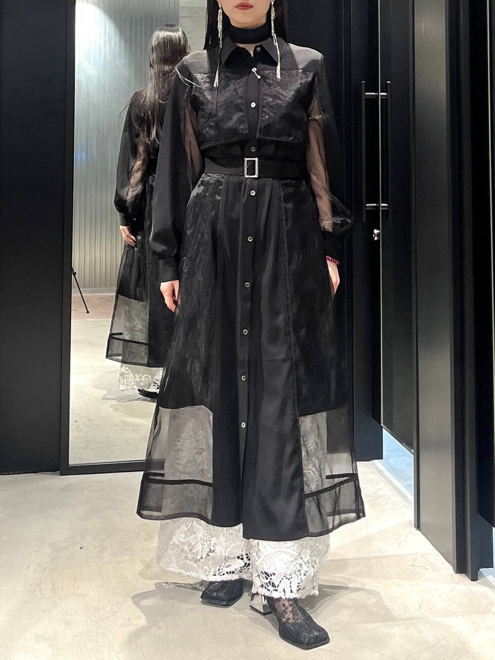 ブラック系のブーツ、ホワイト系のその他パンツ、ブラック系のワンピースを着用したレディースの冬コーディネートの3枚目の写真