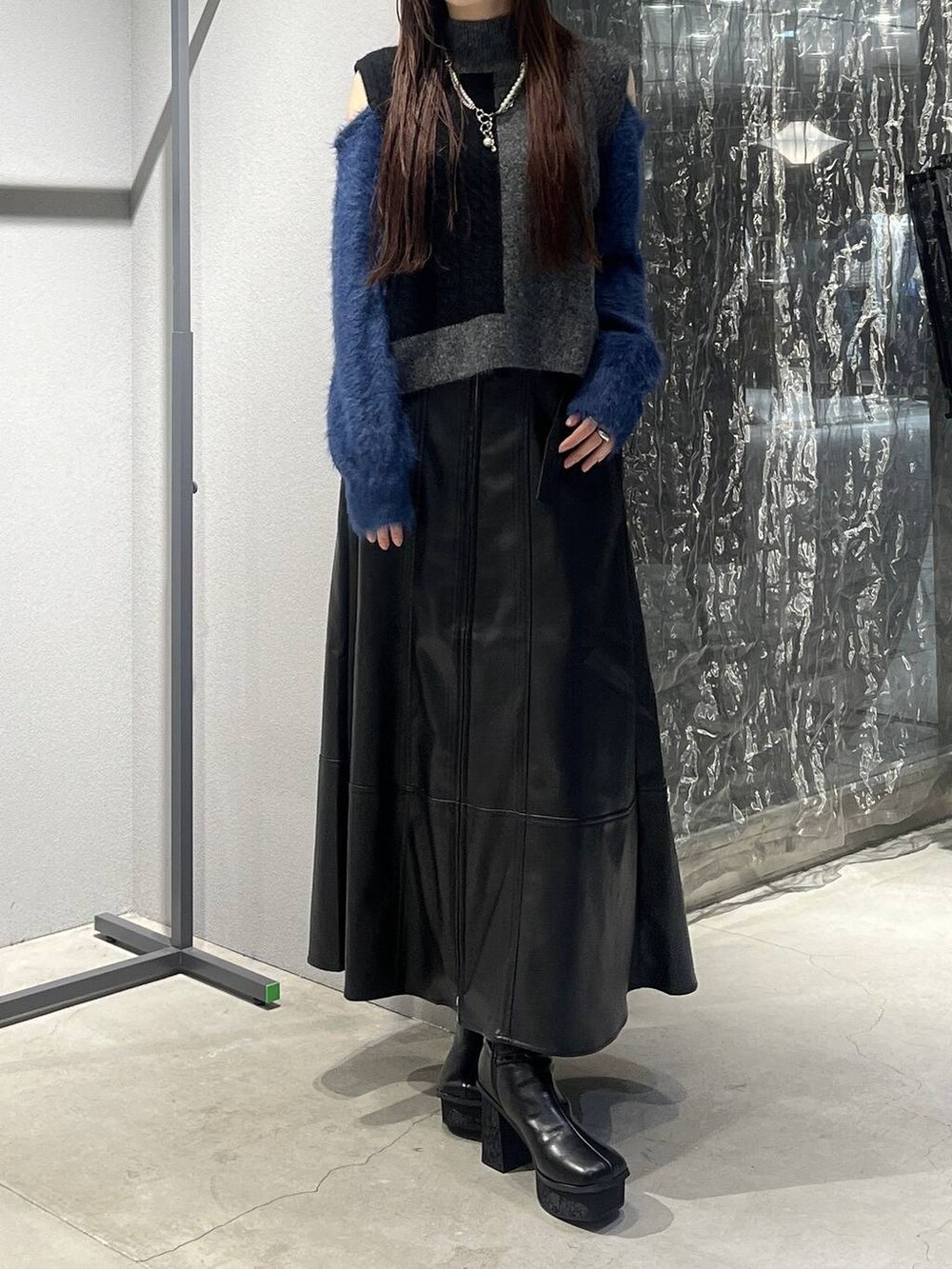 ブラック系のブーツ、ブラック系のニット/セーター、ブラック系のスカートを着用したレディースの秋コーディネートの3枚目の写真