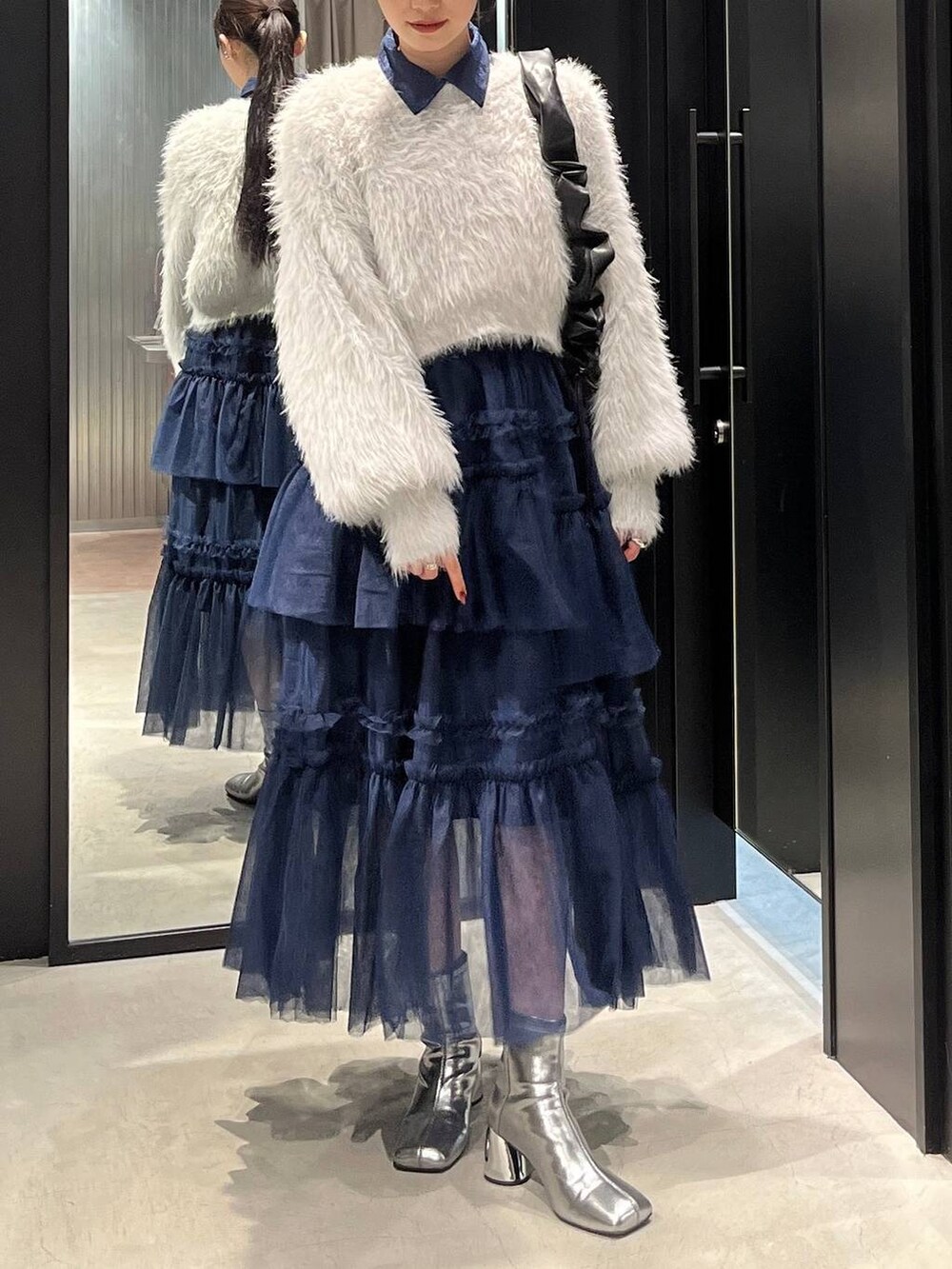 グレー系のニット/セーター、シルバー系のブーツ、ブルー系のシャツ/ブラウスを着用したレディースの秋コーディネートの5枚目の写真