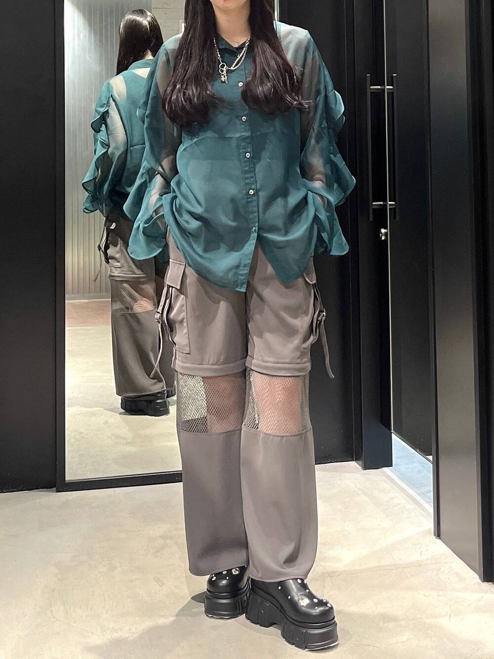 グリーン系のシャツ/ブラウス、ブラック系のサンダル、グレー系のカーゴパンツを着用したレディースの春コーディネートの2枚目の写真