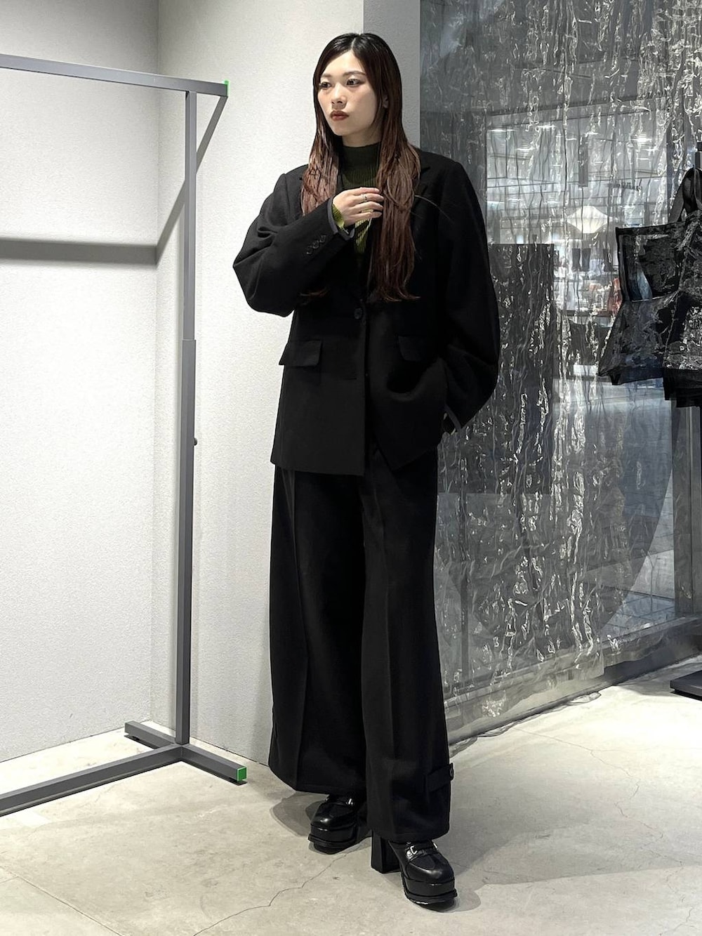 ブラック系のブーツ、イエロー系のニット/セーター、ブラック系のテーラードジャケットを着用したレディースの秋コーディネートの5枚目の写真