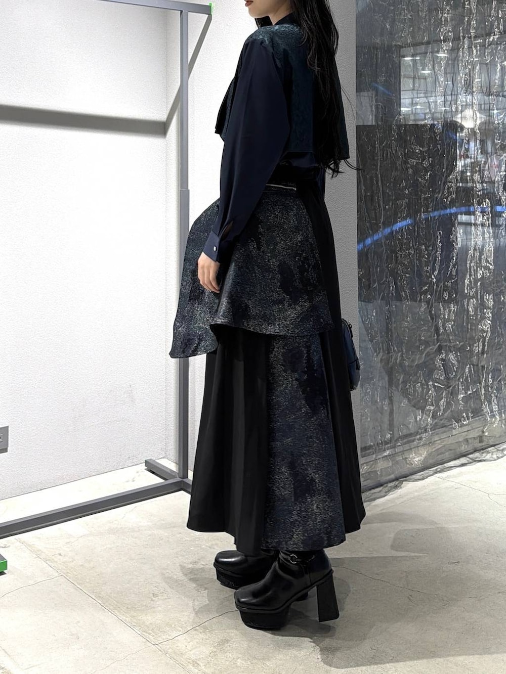 ブラック系のボストンバッグ、ブラック系のブーツ、グリーン系のスカートを着用したレディースの冬コーディネートの3枚目の写真