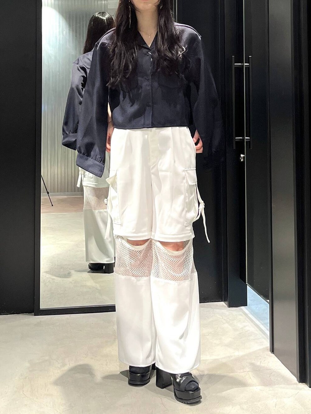 ブラック系のブーツ、ブルー系のシャツ/ブラウス、ホワイト系のカーゴパンツを着用したレディースの春コーディネートの2枚目の写真