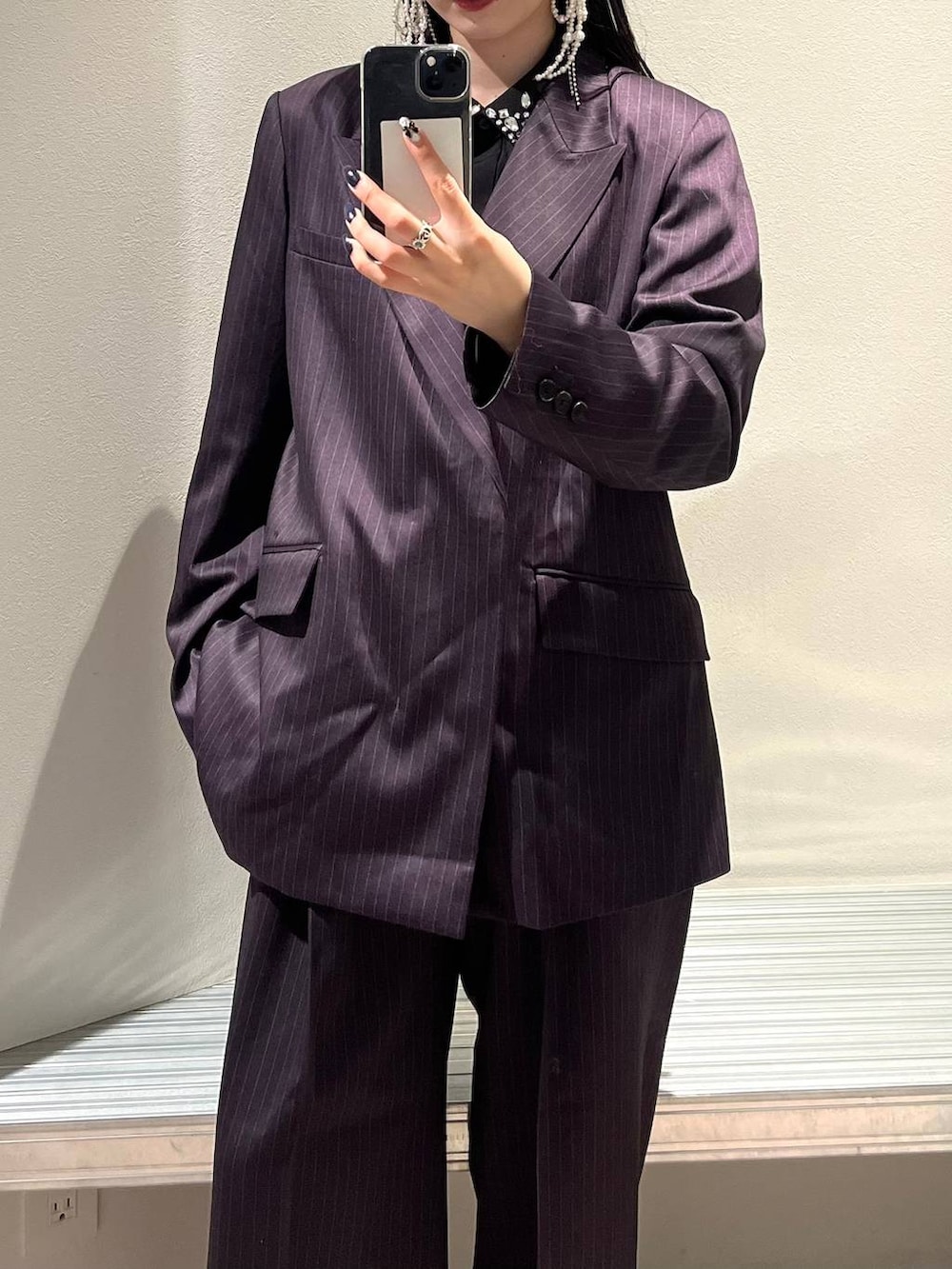 シルバー系のブーツ、ブラック系のシャツ/ブラウス、パープル系のスラックスを着用したレディースの秋コーディネートの4枚目の写真