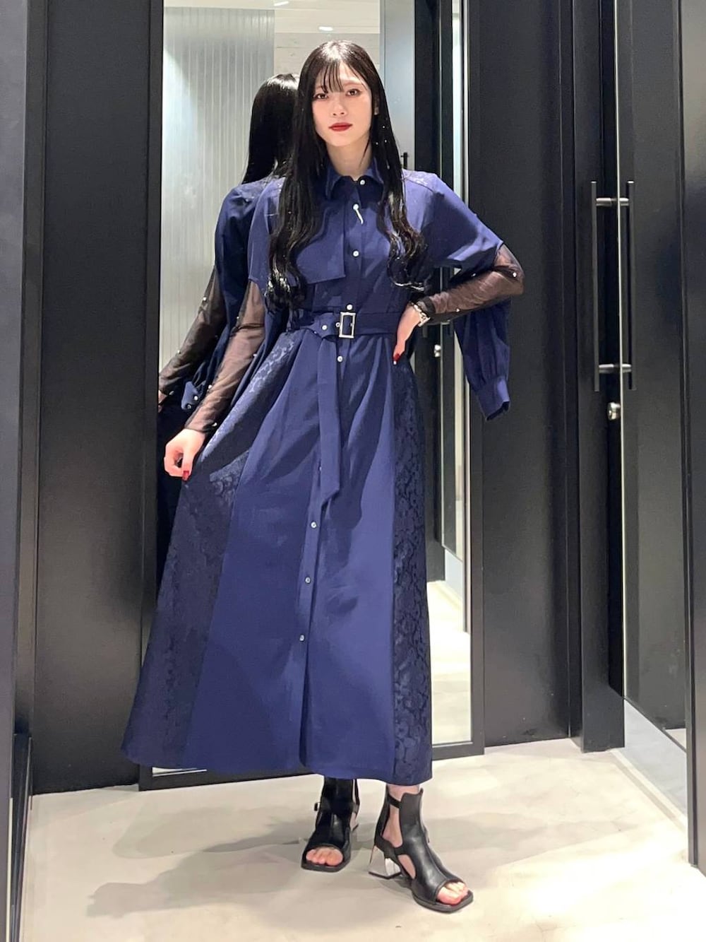 ブルー系のワンピース、ブラック系のサンダル、ブラック系のTシャツ/カットソーを着用したレディースの春コーディネートの2枚目の写真