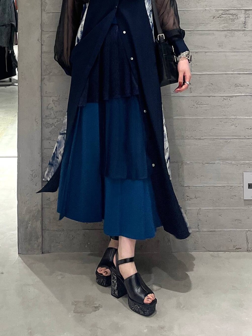 ブルー系のワンピース、ブルー系のスカート、ブラック系のショルダーバッグを着用したレディースの春コーディネートの3枚目の写真