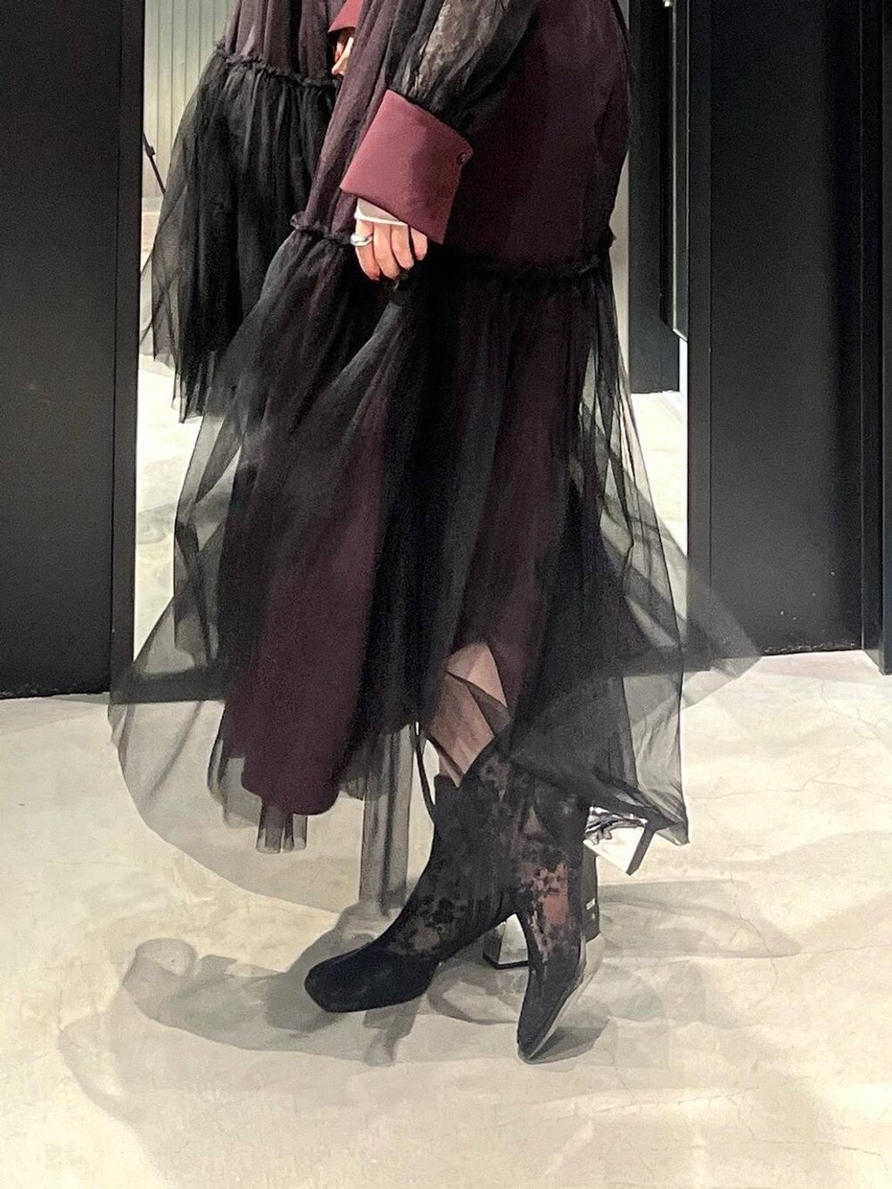 ブラック系のブーツ、レッド系のワンピース、シルバー系のネックレスを着用したレディースの春コーディネートの4枚目の写真