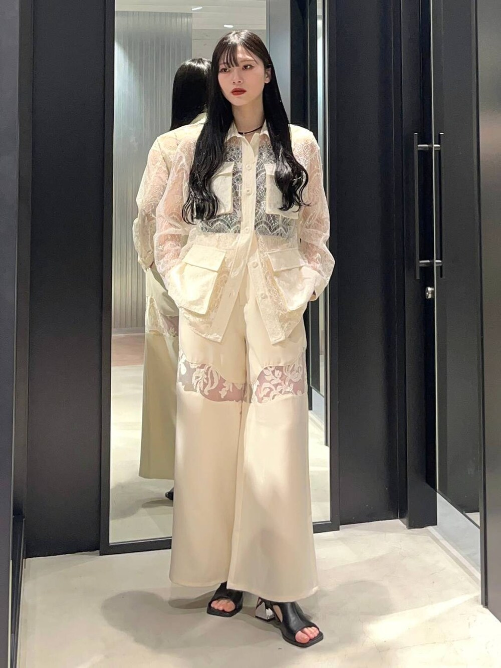 ホワイト系のブルゾン、ブラック系のサンダル、ホワイト系のその他パンツを着用したレディースの春コーディネートの2枚目の写真