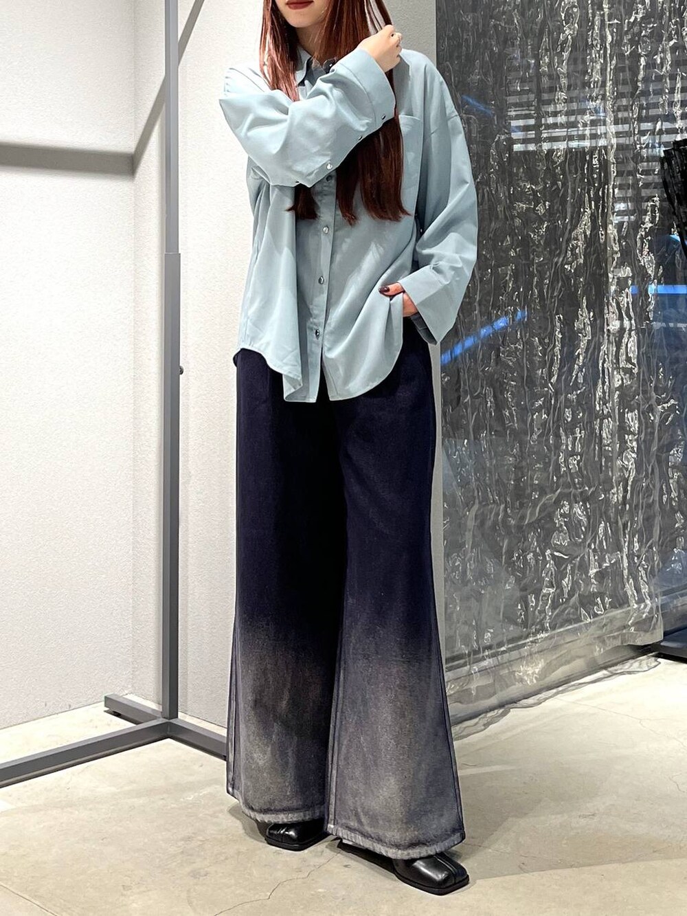 ブラック系のブーツ、ブルー系のデニムパンツを着用したレディースの夏コーディネートの4枚目の写真