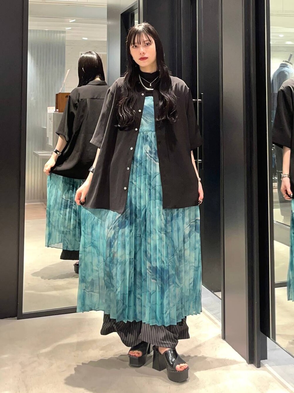 ブラック系のサンダル、グリーン系のワンピース、ブラック系のシャツ/ブラウスを着用したレディースの春コーディネートの2枚目の写真