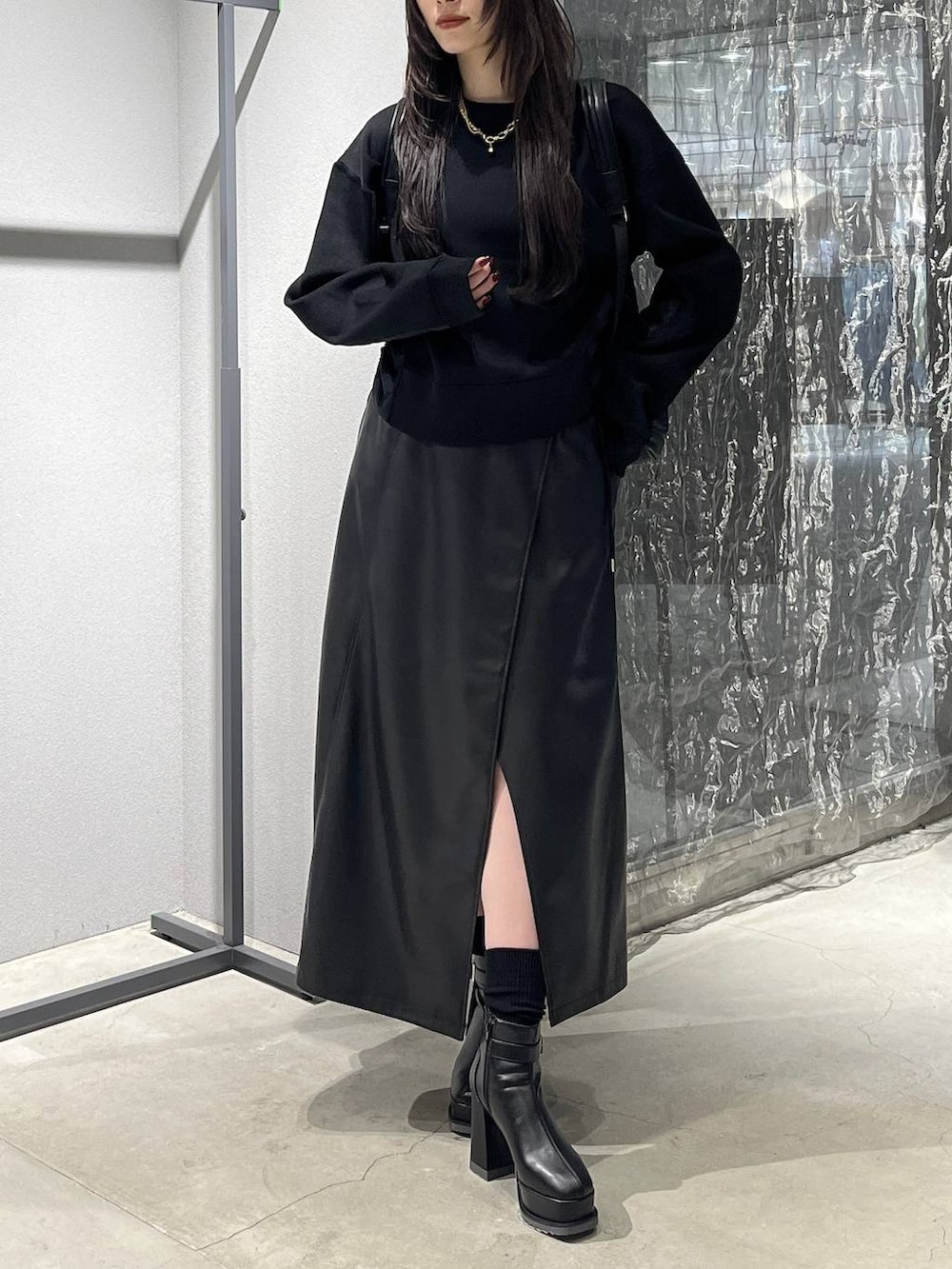 ブラック系のバックパック/リュック、ブラック系のスカート、ブラック系のブーツを着用したレディースの秋コーディネートの2枚目の写真