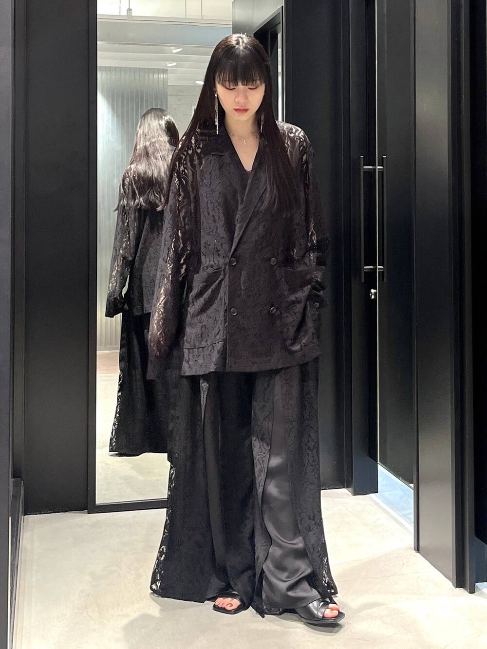 ブラック系のテーラードジャケット、ブラック系のサンダル、ブラック系のその他パンツを着用したレディースの春コーディネートの2枚目の写真