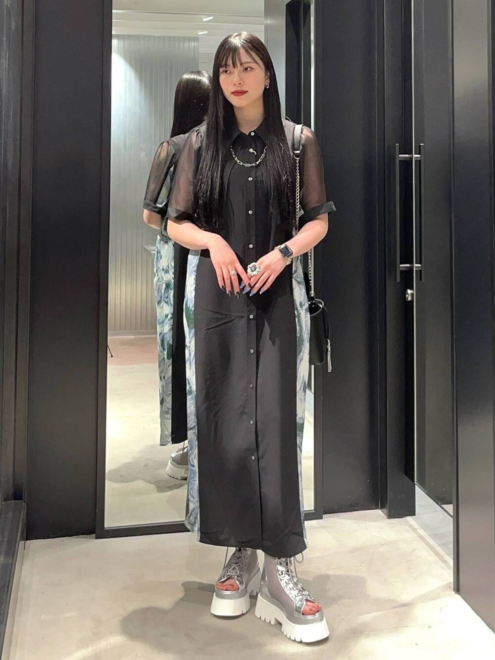 シルバー系のサンダル、グリーン系のワンピース、ブラック系のショルダーバッグを着用したレディースの春コーディネートの2枚目の写真