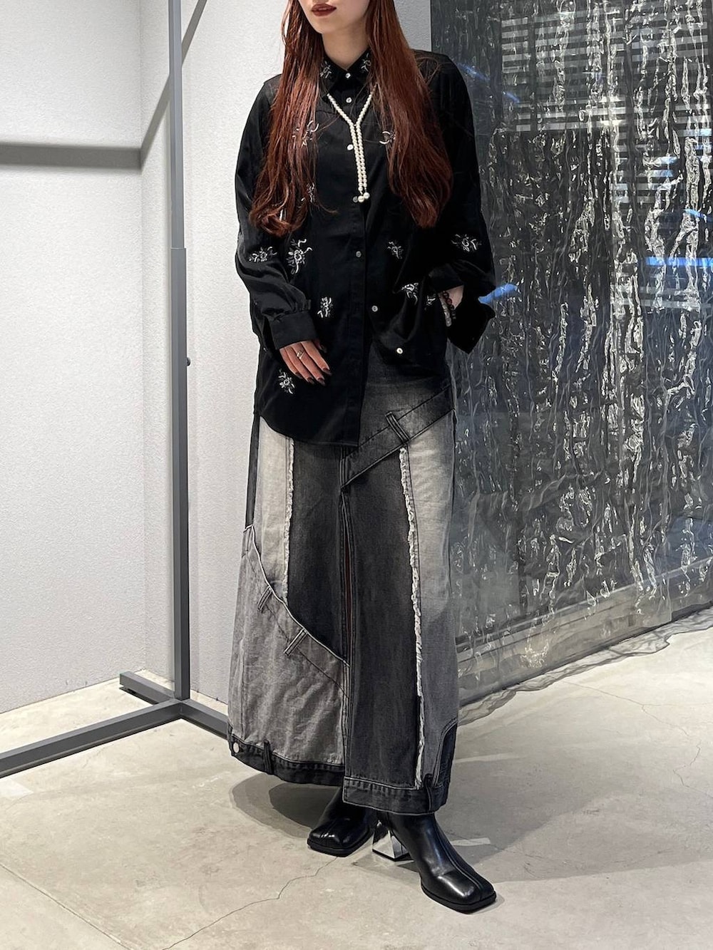 ブラック系のデニムスカート、ブラック系のシャツ/ブラウス、ブラック系のブーツを着用したレディースの秋コーディネートの5枚目の写真