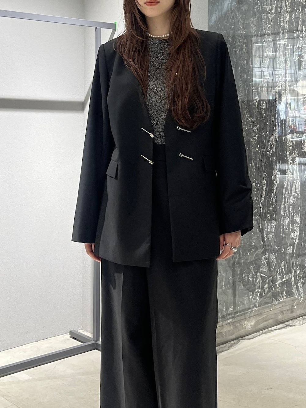 グレー系のブーツ、ブラック系のノーカラージャケット、ブラック系のスラックスを着用したレディースの秋コーディネートの6枚目の写真