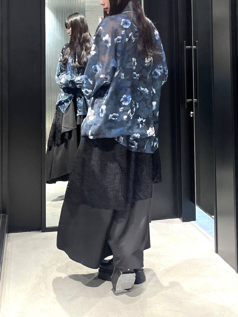 ブラック系のスカート、ブラック系のサンダル、シルバー系のネックレスを着用したレディースの春コーディネートの4枚目の写真