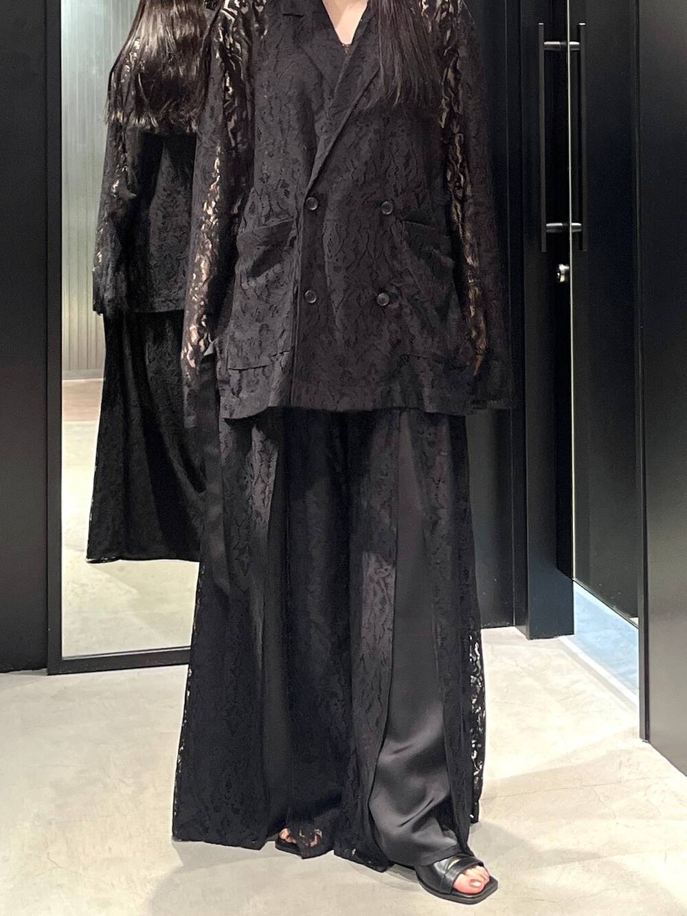 ブラック系のテーラードジャケット、ブラック系のサンダル、ブラック系のその他パンツを着用したレディースの春コーディネートの4枚目の写真