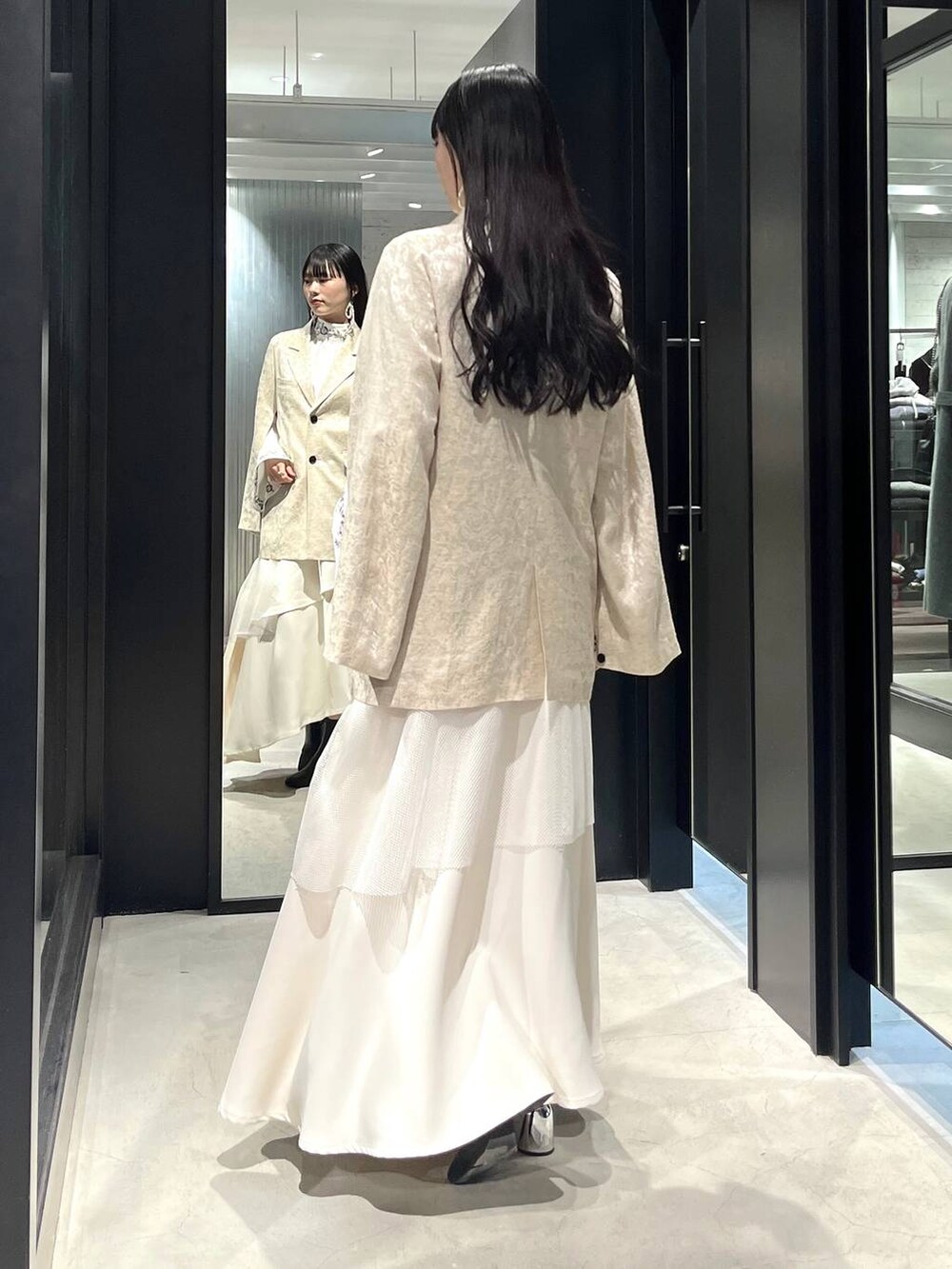 ブラック系のブーツ、ホワイト系のシャツ/ブラウス、ホワイト系のテーラードジャケットを着用したレディースの冬コーディネートの5枚目の写真