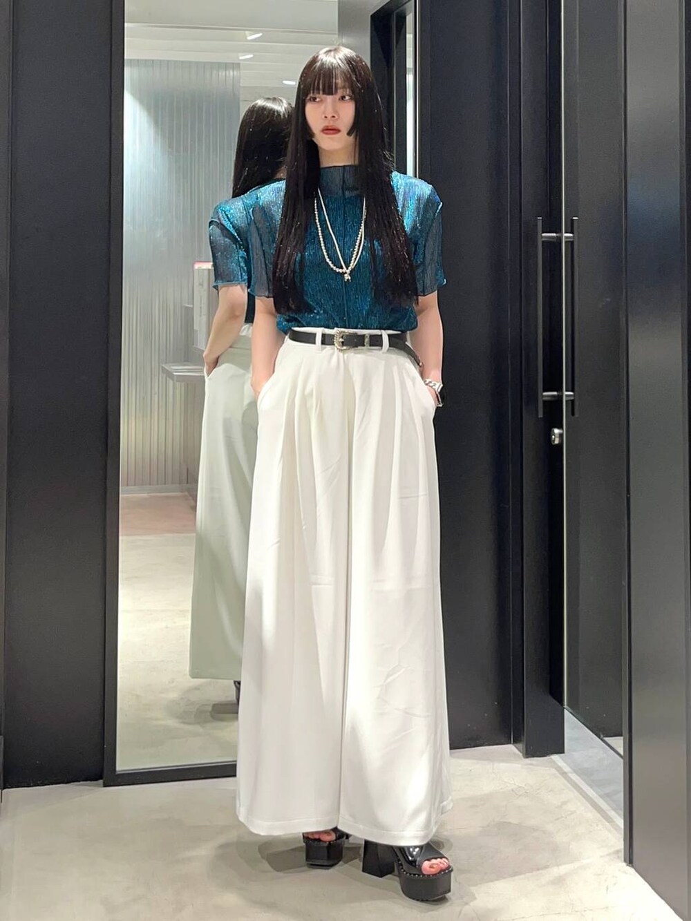 ブラック系のサンダル、ブルー系のTシャツ/カットソー、ホワイト系のスラックスを着用したレディースの春コーディネートの2枚目の写真