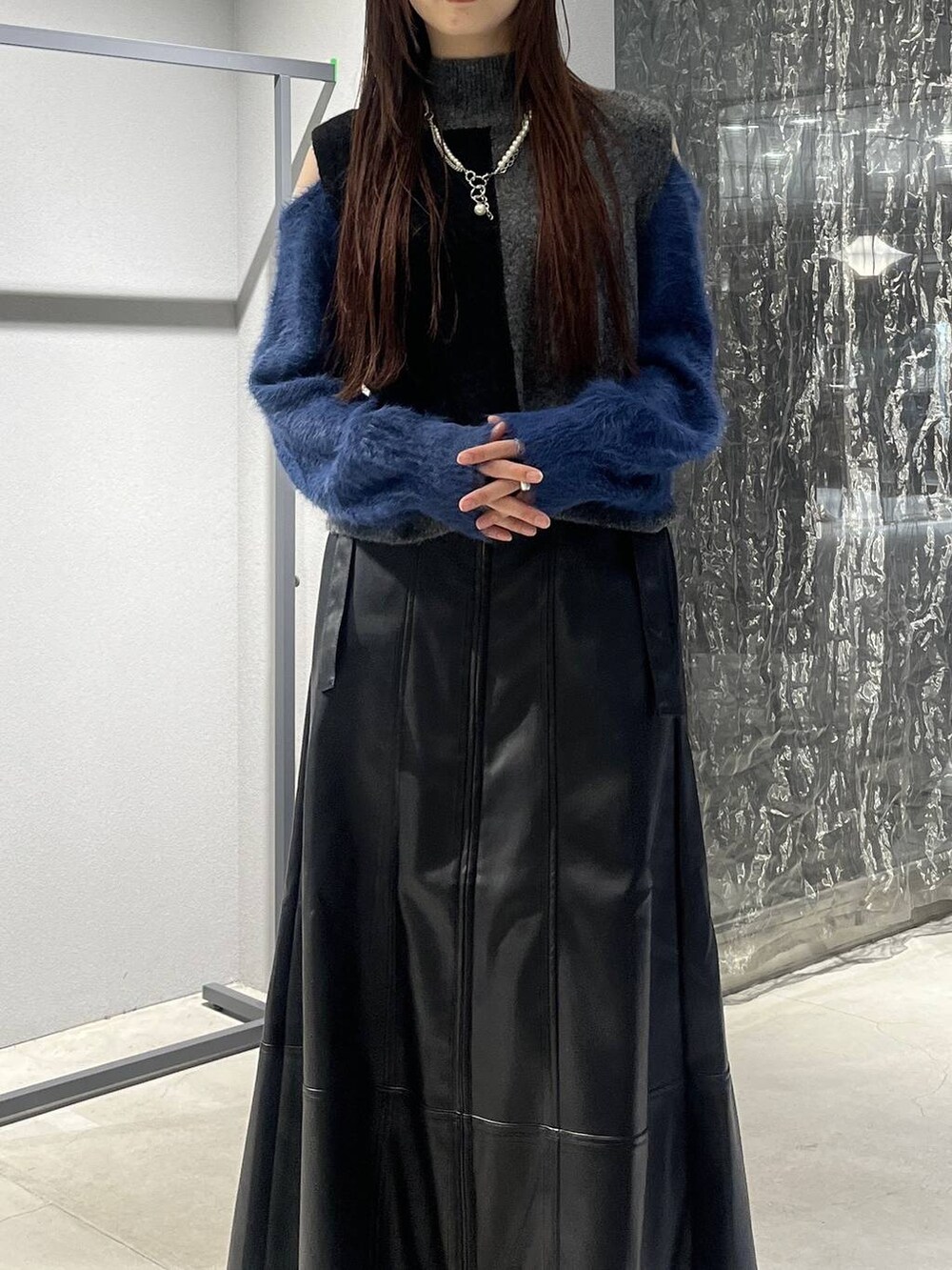 ブラック系のブーツ、ブラック系のニット/セーター、ブラック系のスカートを着用したレディースの秋コーディネートの4枚目の写真