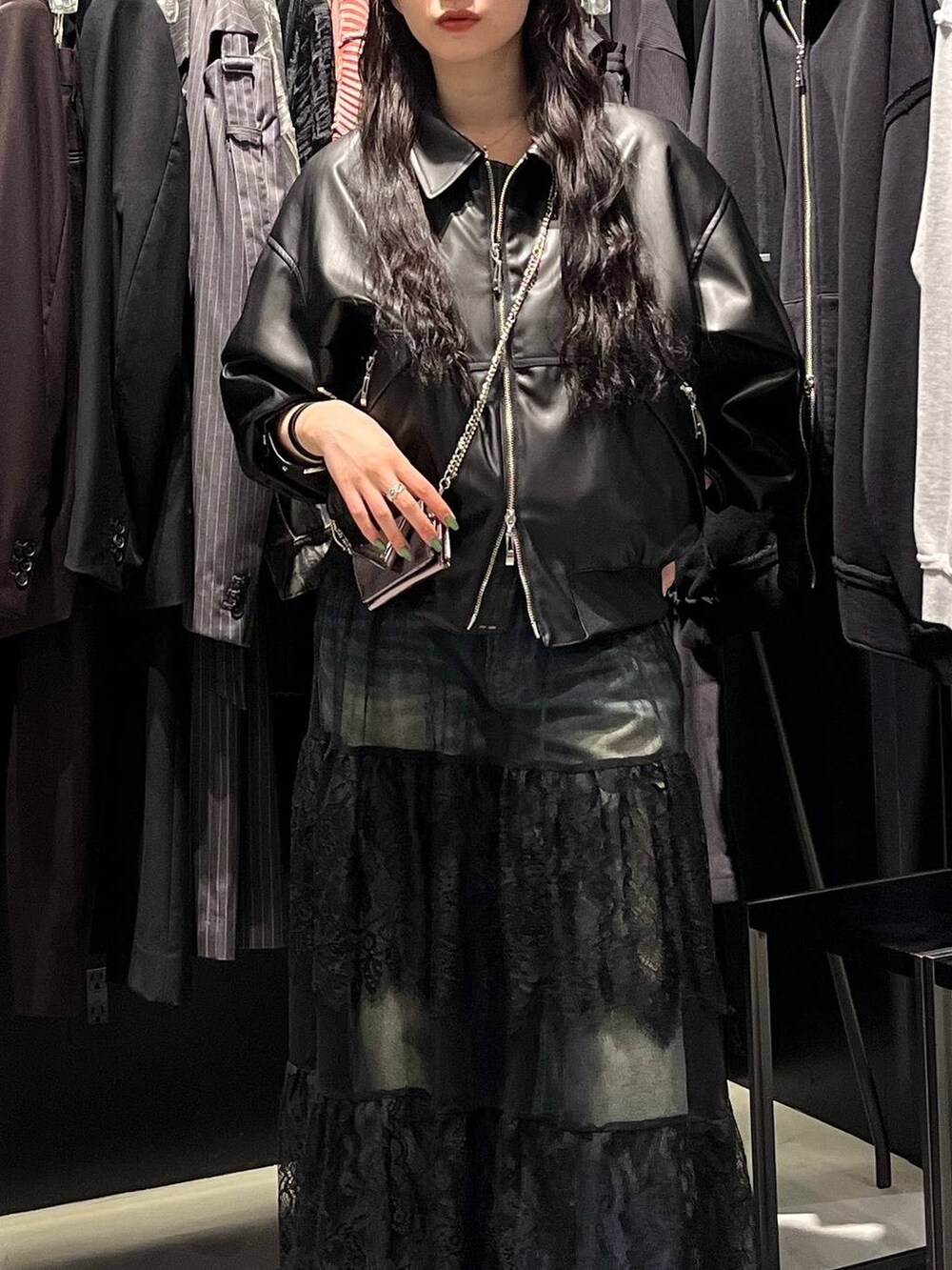 ブルー系のデニムパンツ、ブラック系のブーツ、ブラック系のブルゾンを着用したレディースの秋コーディネートの3枚目の写真