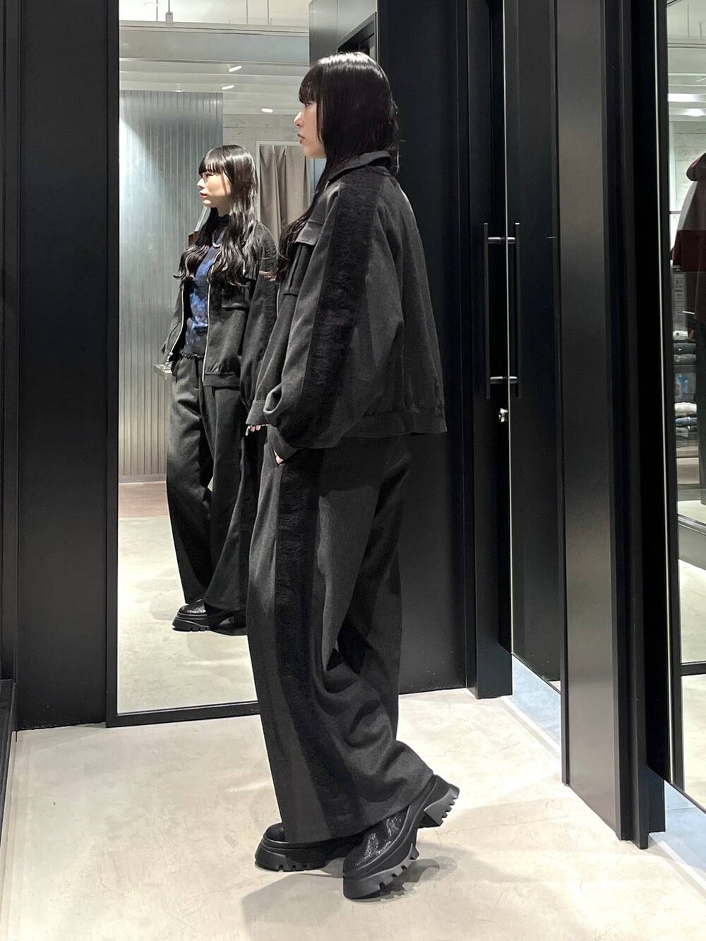 ブラック系のブーツ、ブルー系のTシャツ/カットソー、グレー系のブルゾンを着用したレディースの冬コーディネートの2枚目の写真