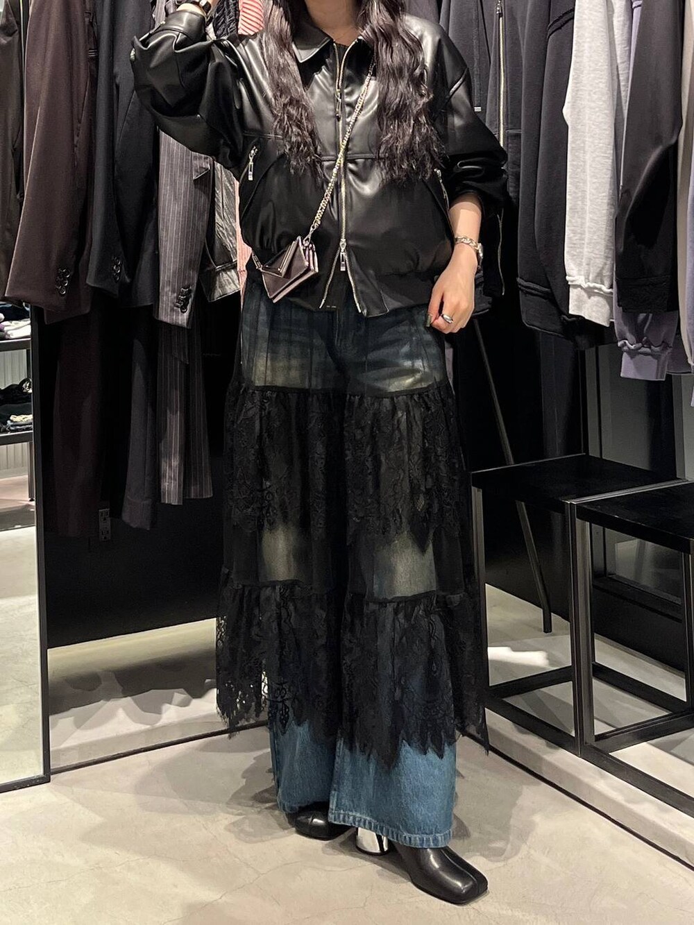 ブルー系のデニムパンツ、ブラック系のブーツ、ブラック系のブルゾンを着用したレディースの秋コーディネートの2枚目の写真