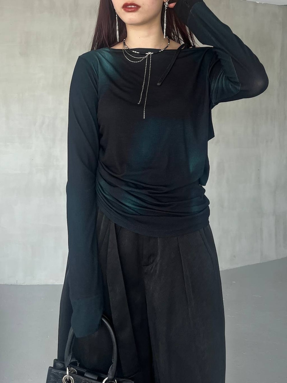 ブラック系のショルダーバッグ、ブラック系のその他パンツ、グリーン系のTシャツ/カットソーを着用したレディースの夏コーディネートの9枚目の写真