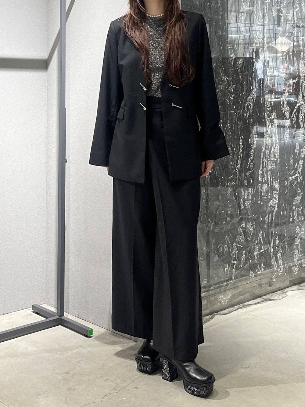 グレー系のブーツ、ブラック系のノーカラージャケット、ブラック系のスラックスを着用したレディースの秋コーディネートの5枚目の写真