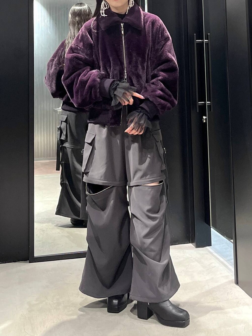 グレー系のカーゴパンツ、ブラック系のブーツ、ブラック系のTシャツ/カットソーを着用したレディースの冬コーディネートの2枚目の写真