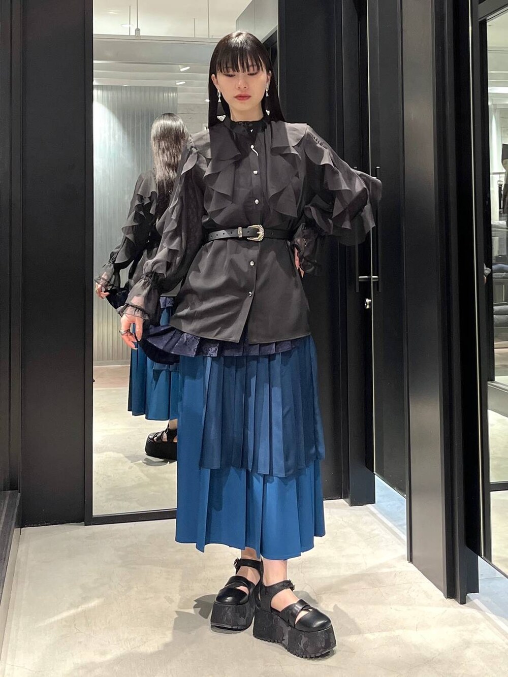 ブラック系のサンダル、ブラック系のシャツ/ブラウス、ブルー系のスカートを着用したレディースの春コーディネートの5枚目の写真