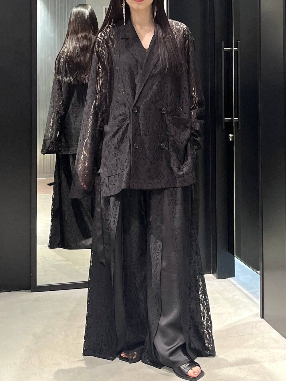 ブラック系のテーラードジャケット、ブラック系のサンダル、ブラック系のその他パンツを着用したレディースの春コーディネートの3枚目の写真