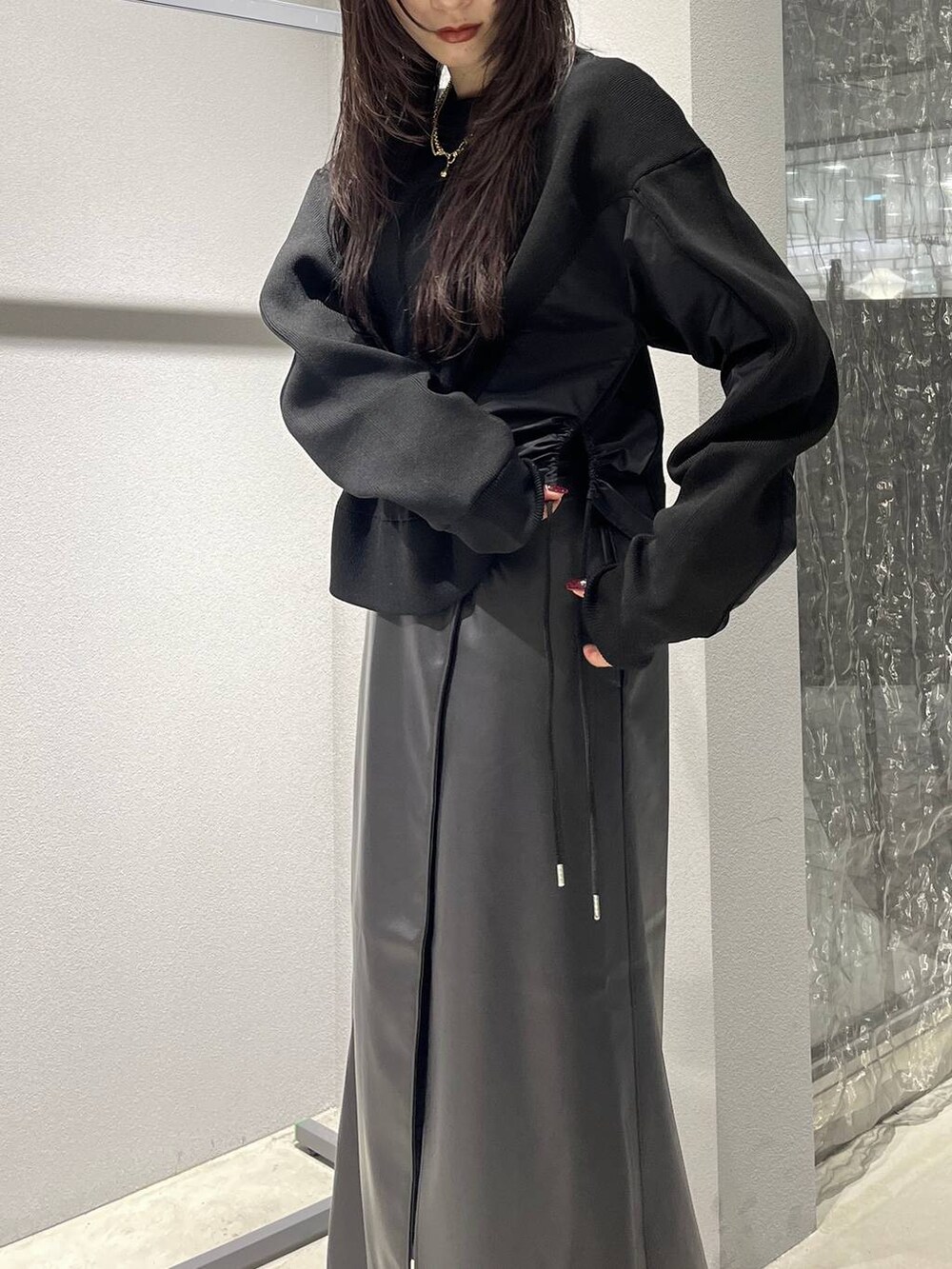 ブラック系のバックパック/リュック、ブラック系のスカート、ブラック系のブーツを着用したレディースの秋コーディネートの4枚目の写真