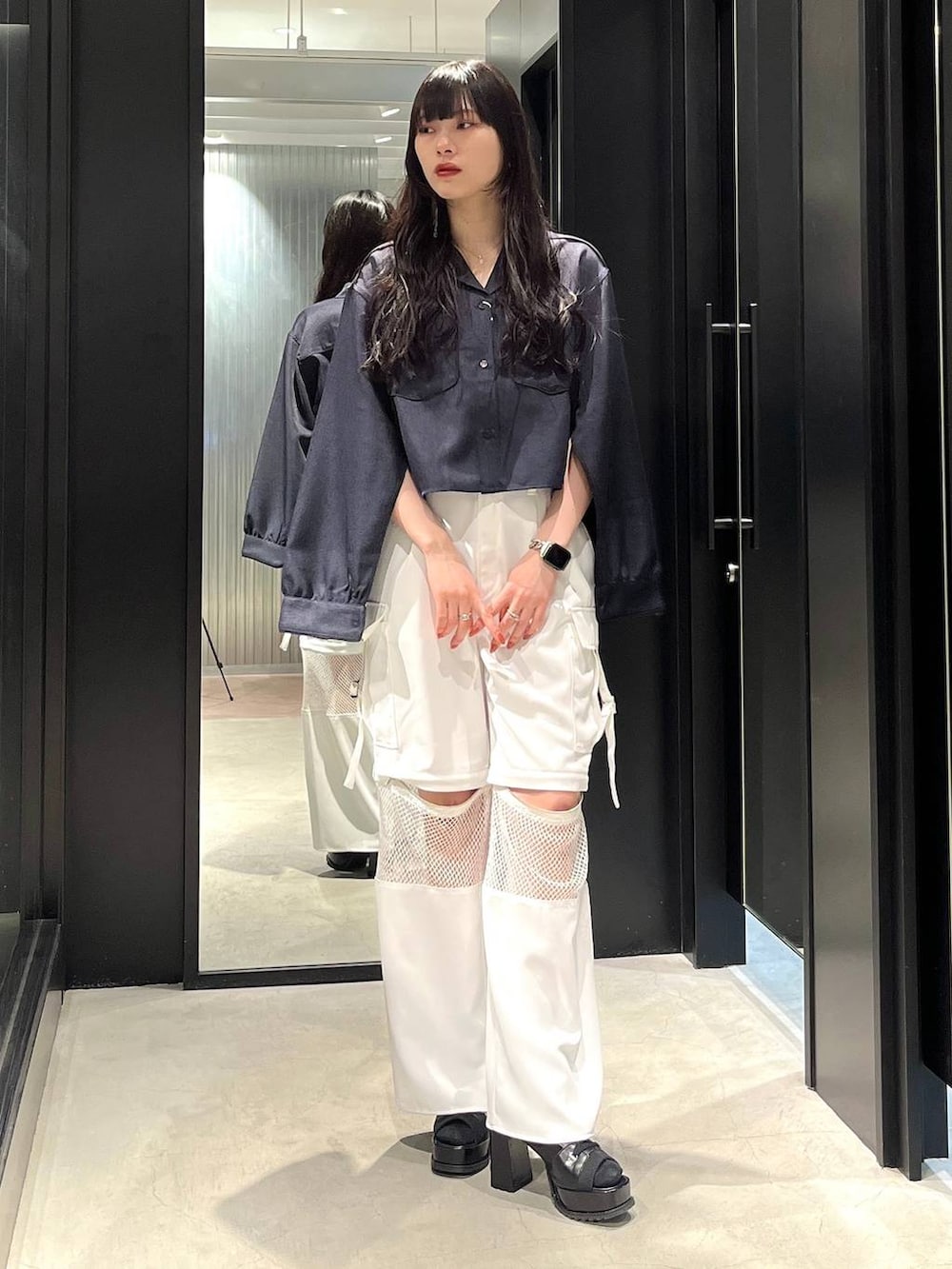 ブラック系のブーツ、ブルー系のシャツ/ブラウス、ホワイト系のカーゴパンツを着用したレディースの春コーディネートの3枚目の写真