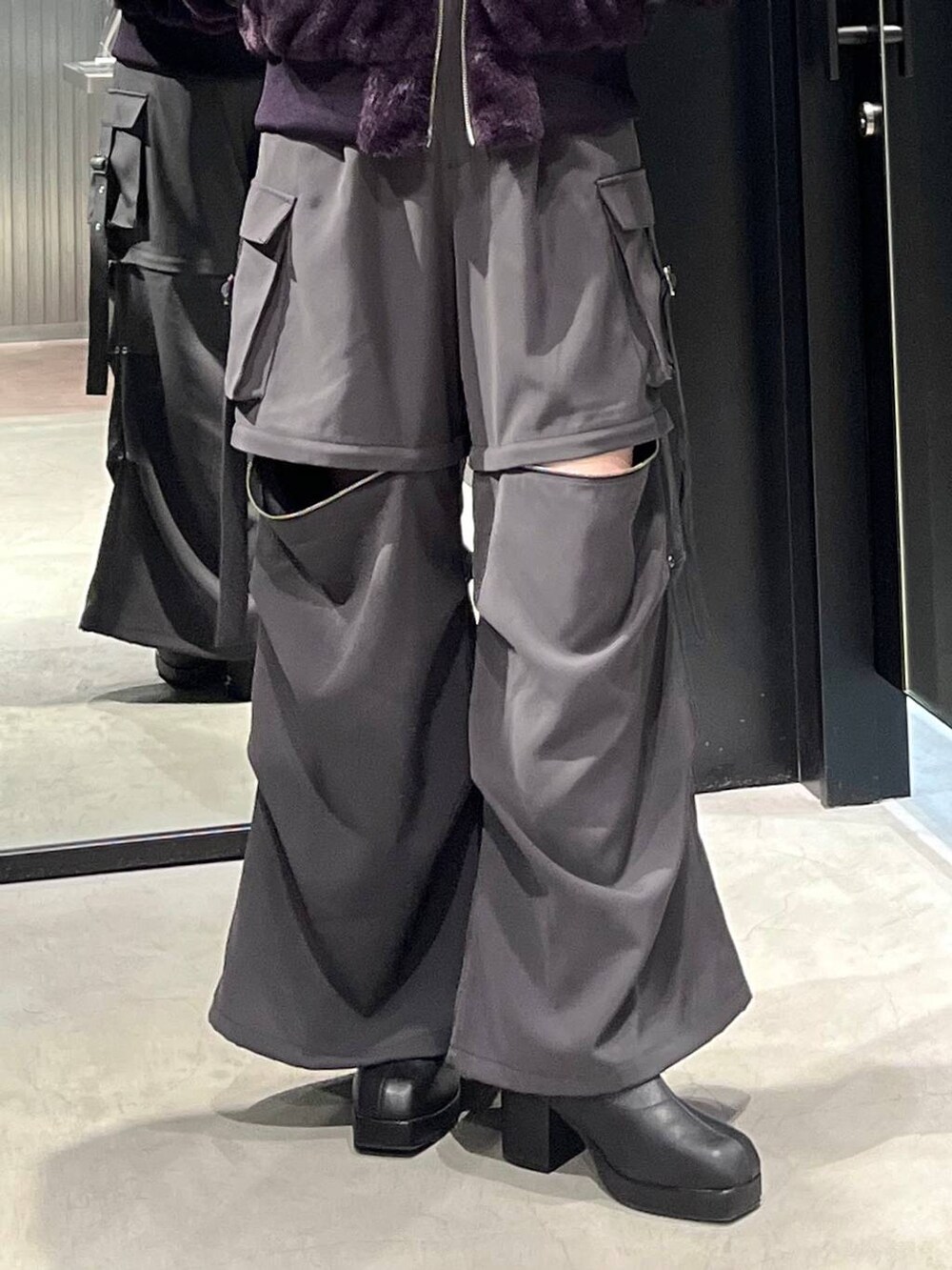 グレー系のカーゴパンツ、ブラック系のブーツ、ブラック系のTシャツ/カットソーを着用したレディースの冬コーディネートの4枚目の写真