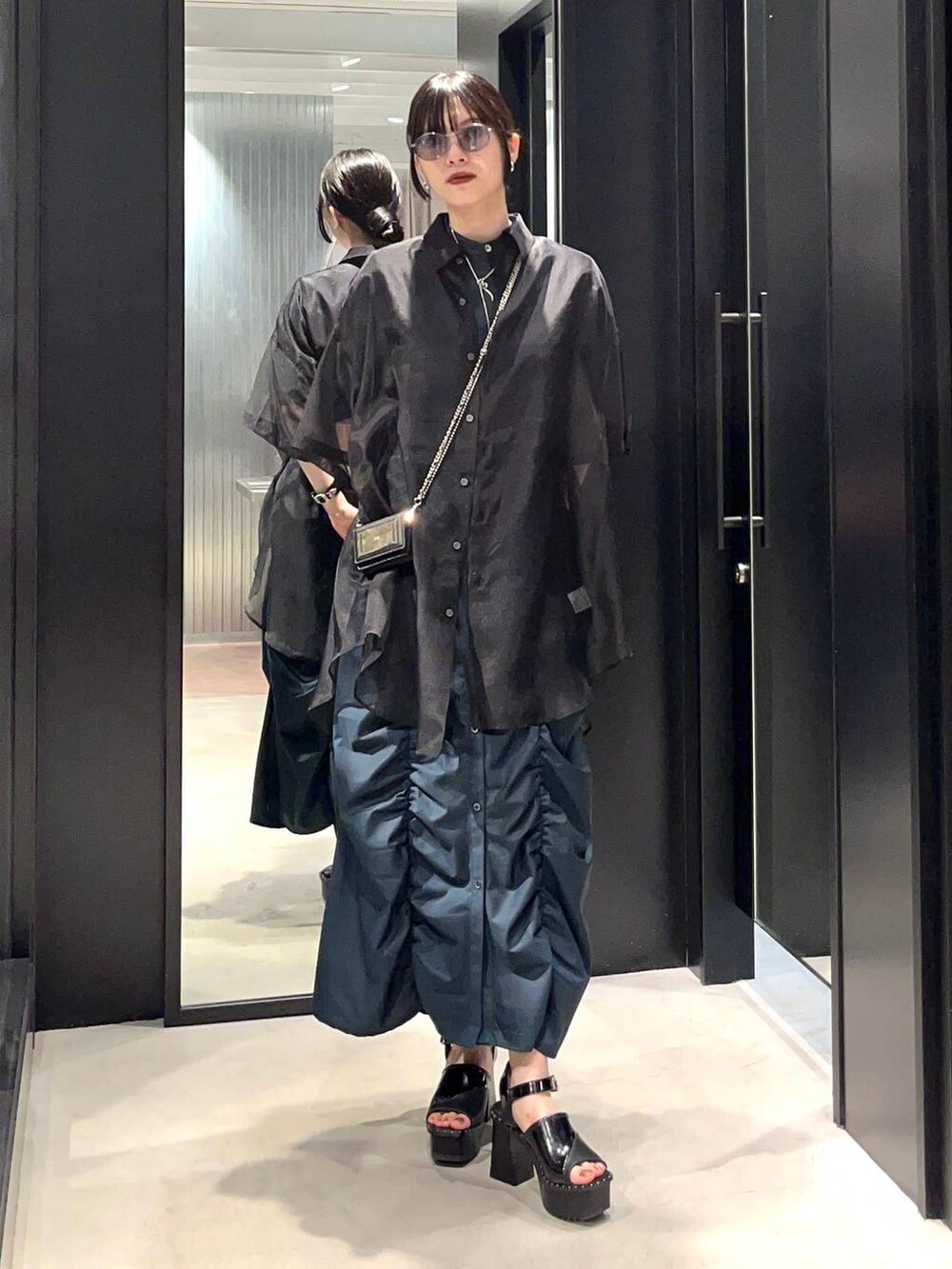 ブラック系のサンダル、ブラック系のシャツ/ブラウス、グリーン系のワンピースを着用したレディースの春コーディネートの3枚目の写真