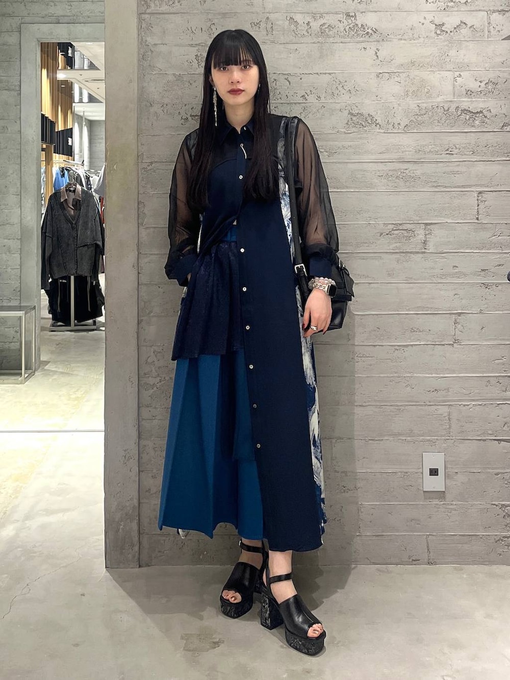 ブルー系のワンピース、ブルー系のスカート、ブラック系のショルダーバッグを着用したレディースの春コーディネートの5枚目の写真