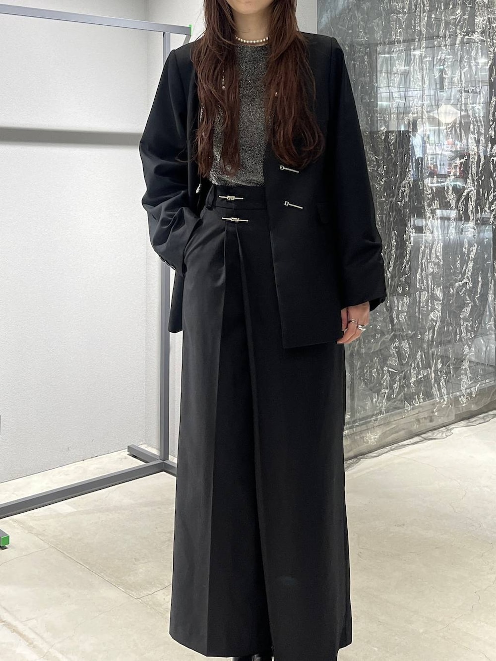 グレー系のブーツ、ブラック系のノーカラージャケット、ブラック系のスラックスを着用したレディースの秋コーディネートの2枚目の写真